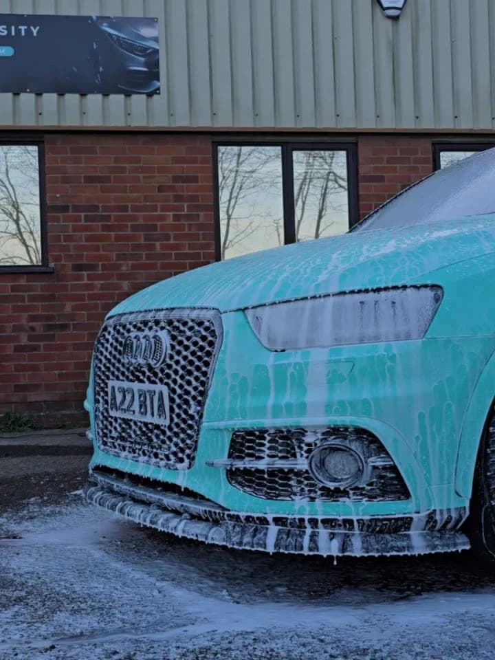 Turquoise Audi under snow foam before a ceramic coating