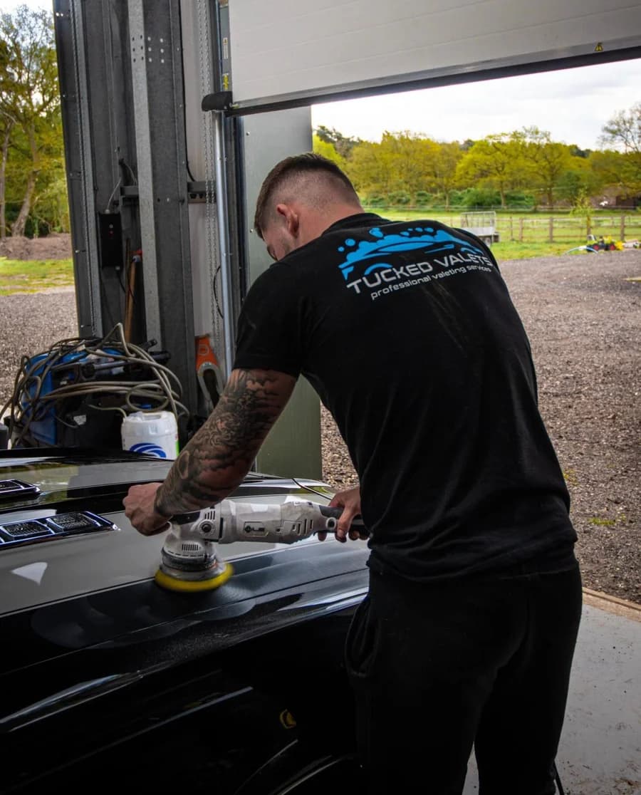 Ashley Tuckfield, founder of Tucked Valets, machine polishing a car bonnet